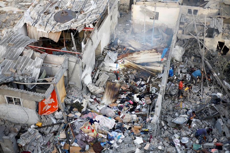 I palestinesi ispezionano il luogo in cui sorgeva una casa colpita da un attacco aereo israeliano a Nuseirat, nella Striscia di Gaza centrale (REUTERS)