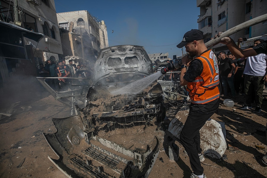 I vigili del fuoco palestinesi tentano di spegnere un incendio in un veicolo distrutto da un attacco aereo israeliano a sud della città di Gaza (EPA)