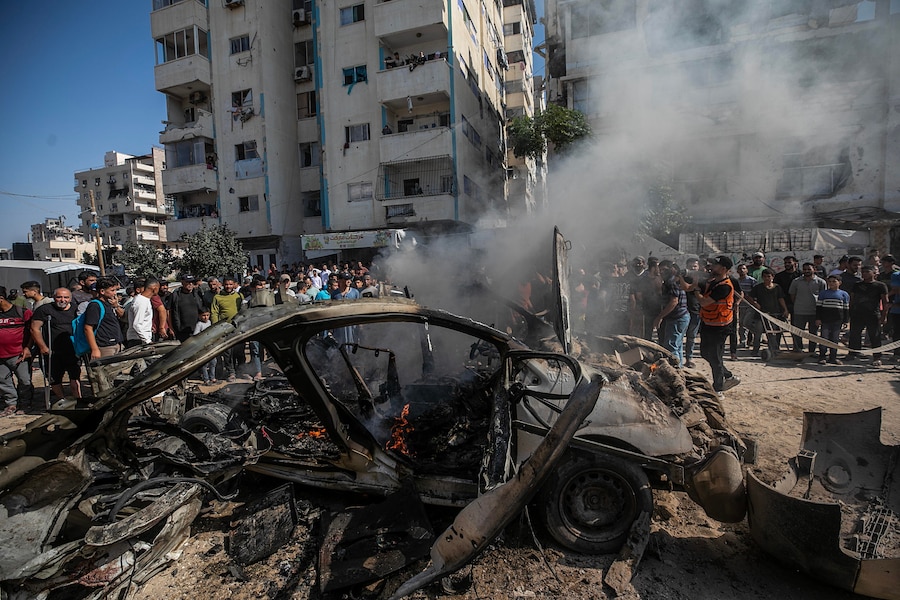 I vigili del fuoco palestinesi tentano di spegnere un incendio in un veicolo distrutto da un attacco aereo israeliano a sud della città di Gaza (EPA)