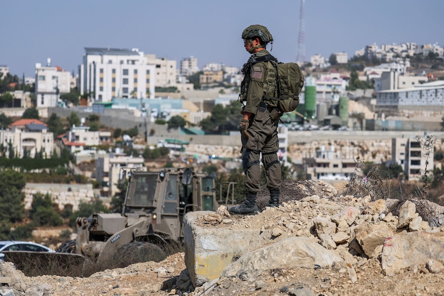 Un membro delle forze armate israeliane sorveglia la zona il giorno in cui il primo ministro israeliano Benjamin Netanyahu si reca sul posto in seguito a una sparatoria avvenuta a Hebron, nella Cisgiordania occupata da Israele, il 23 ottobre 2026. (REUTERS)