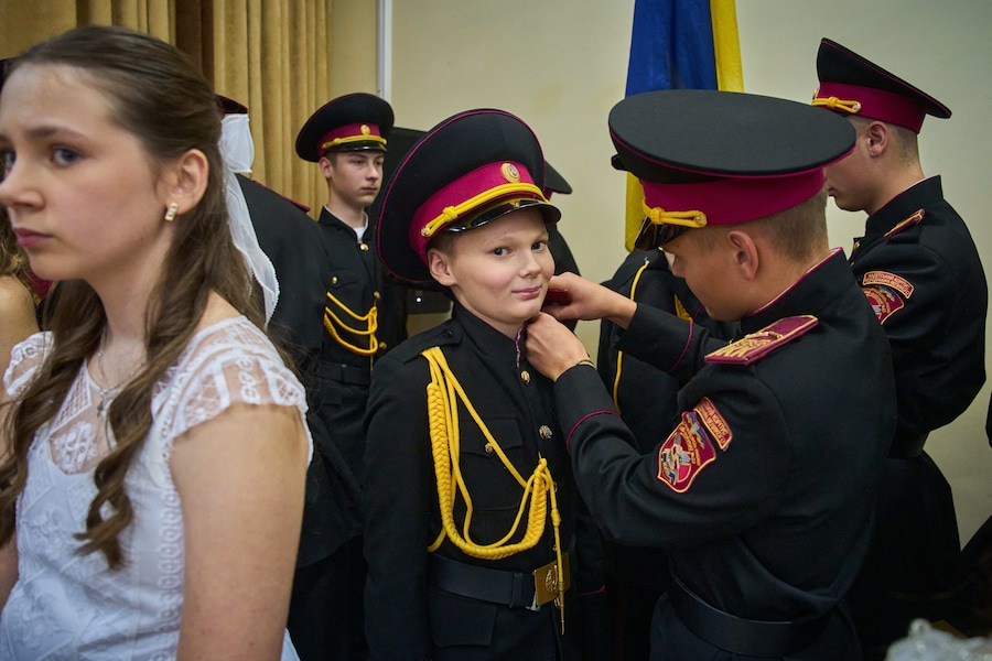 Un diplomato allaccia le spalline a un giovane cadetto durante la cerimonia di iniziazione presso un liceo militare a Kiev, venerdì 23 ottobre 2026. ( (APN)