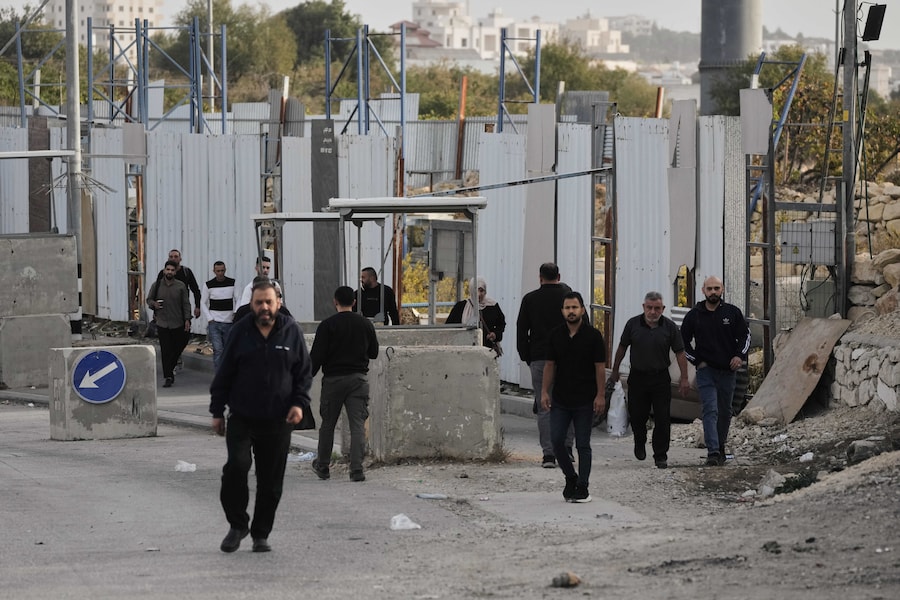 Sabato 24 ottobre 2026, nella Cisgiordania occupata, alcuni palestinesi attraversano a piedi un posto di blocco militare chiuso al traffico veicolare durante un’operazione dell’esercito israeliano a Hebron. (APN)