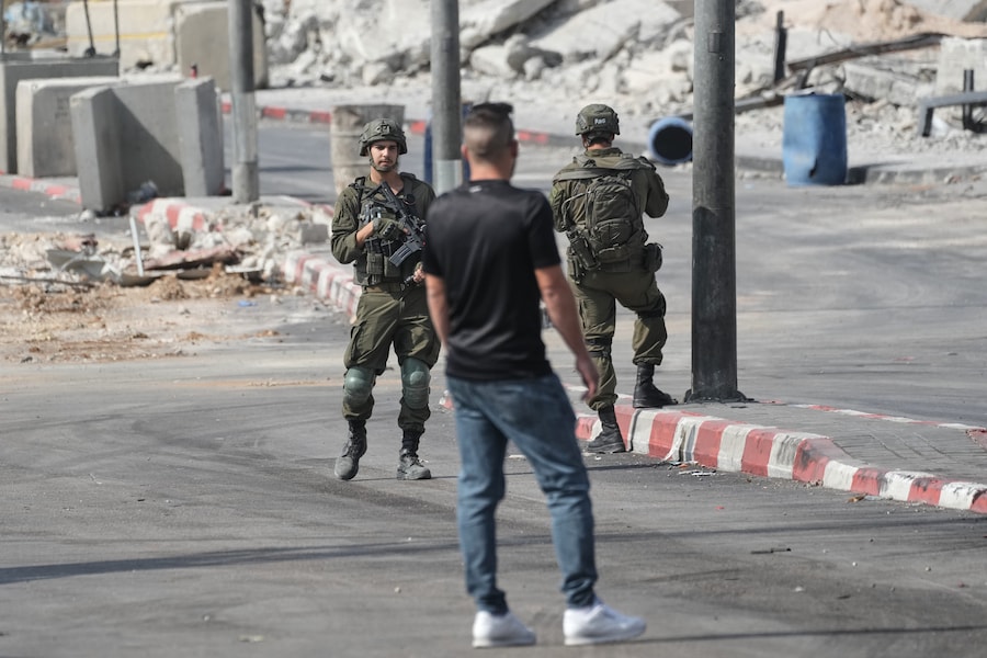 Un uomo palestinese e alcuni soldati israeliani durante un’operazione militare nella città di Hebron, in Cisgiordania, sabato 24 ottobre 2026. Il giorno dopo un attacco armato compiuto da un palestinese nella zona. (APN)