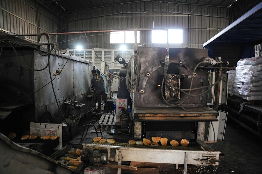 In un panificio di Deir al-Balah, nella Striscia di Gaza centrale, i palestinesi preparano il pane utilizzando la farina fornita da un comitato egiziano. (APN)