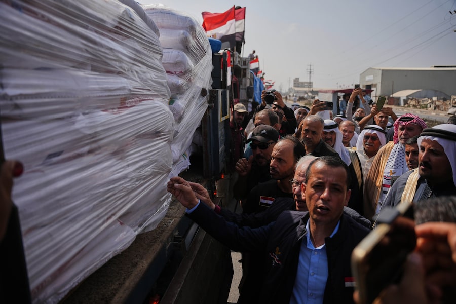 Sabato 24 ottobre 2026, alcuni palestinesi si radunano attorno ai camion che trasportano la farina fornita da un comitato egiziano a un panificio di Deir al-Balah, nella Striscia di Gaza centrale. (APN)