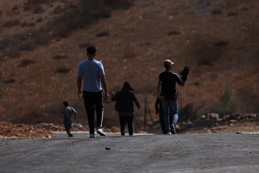Alcuni residenti palestinesi del villaggio di Sinjil, in Cisgiordania, bloccano una strada in seguito agli attacchi sferrati dai coloni israeliani contro alcuni contadini intenti alla raccolta delle olive nei pressi del villaggio, il 24 ottobre 2026. (EPA)