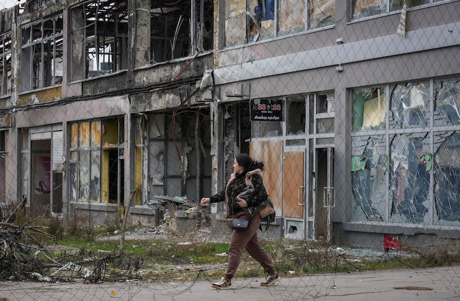 Una donna cammina su una strada ricoperta da una rete anti-drone nella città di Kherson. (REUTERS)