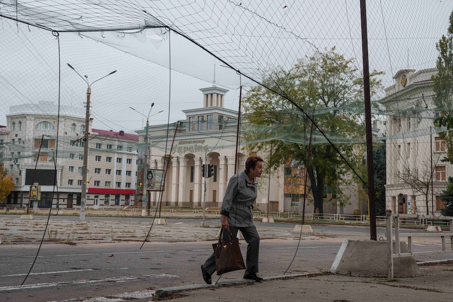 Una donna cammina su un marciapiede sotto le reti anti-drone durante la tregua legata alle operazioni di evacuazione a Oleshky, nella regione di Kherson, in Ucraina, martedì 27 ottobre 2026. (APN)