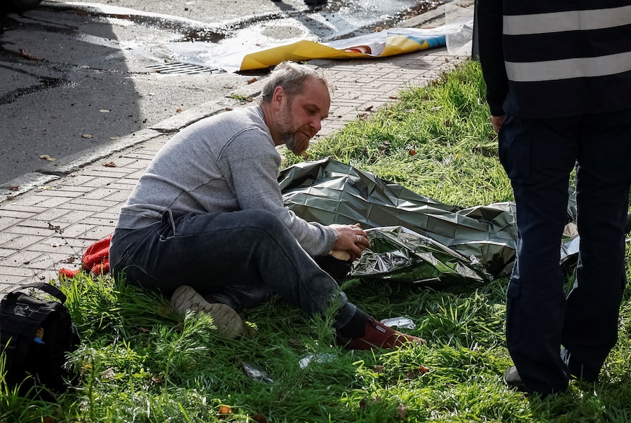 Un uomo vegli il corpo di un parente sul luogo dell'attacco sferrato da un drone russo nel centro di Chernihiv, Ucraina, il 29 ottobre 2026. (REUTERS)