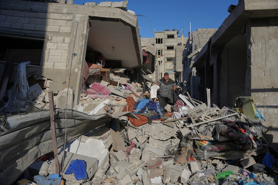 Palestinesi setacciano le macerie di un edificio distrutto durante un attacco israeliano sferrato nella notte nel campo profughi di Bureij, nella Striscia di Gaza centrale. (AP Photo/Abdel Kareem Hana/APN)