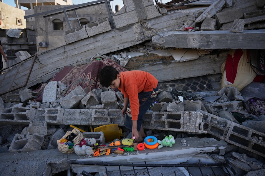 Un bimbo di 8 anni, cerca i suoi giocattoli tra le macerie della sua casa, distrutta durante un attacco aereo israeliano avvenuto nella notte, nel campo profughi di Bureij, nella Striscia di Gaza centrale. (AP Photo/Abdel Kareem Hana/APS)