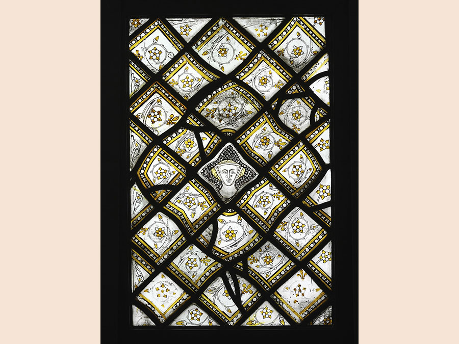 Stained Glass Panel with Quarries and a Female Head, about 1320-4. Paris. Grisaille glass with silver stain, 59.5 x 39 cm. © Victoria and Albert Museum, London 