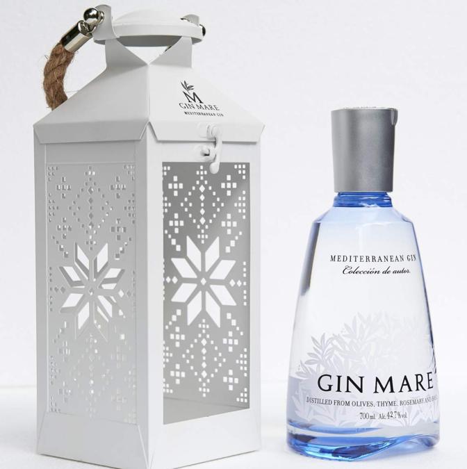 SPIRITI ILLUMINATI - Una lanterna bianca in metallo, perfetta come portacandele o addobbo natalizio grazie alle sue delicate decorazioni a forma di fiocco di neve. Dentro, una bottiglia di Gin Mare da 700ml, il gin prodotto tra la Costa Brava e la Costa Dorada con quattro botaniche principali – basilico, timo, rosmarino e oliva Arbequina, cultivar tipica della Catalogna - accanto ai più classici ginepro, coriandolo e cardamomo. Prezzo: 46 €. www.ginmare.com