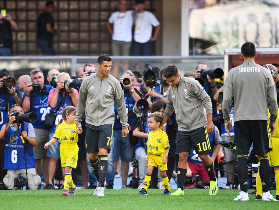 Cristiano Ronaldo e Paulo Dybala entrano sul terreno di gioco. (Alberto PIZZOLI / AFP)