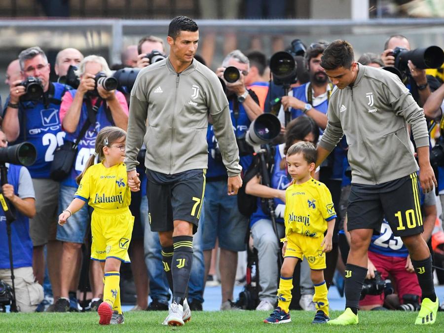 Cristiano Ronaldo e Paulo Dybala entrano sul terreno di gioco. (Alberto PIZZOLI / AFP)