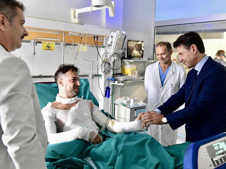 Il presidente del Consiglio Giuseppe Conte in visita  all'ospedale Bufalini di Cesena per incontrare l'agente di Polizia Riccardo Muci (Ansa)