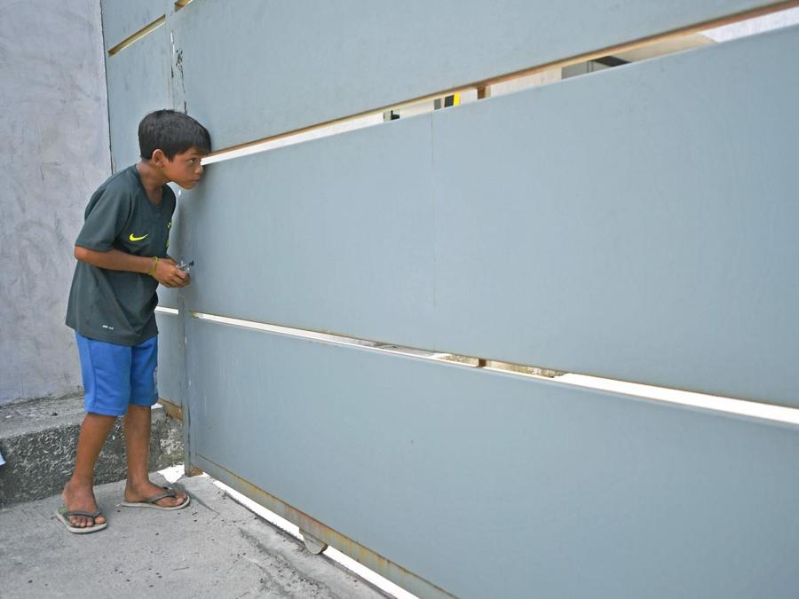 Un ragazzo curiosa all’interno del centro sportivo del Flamengo. (Photo by CARL DE SOUZA / AFP)