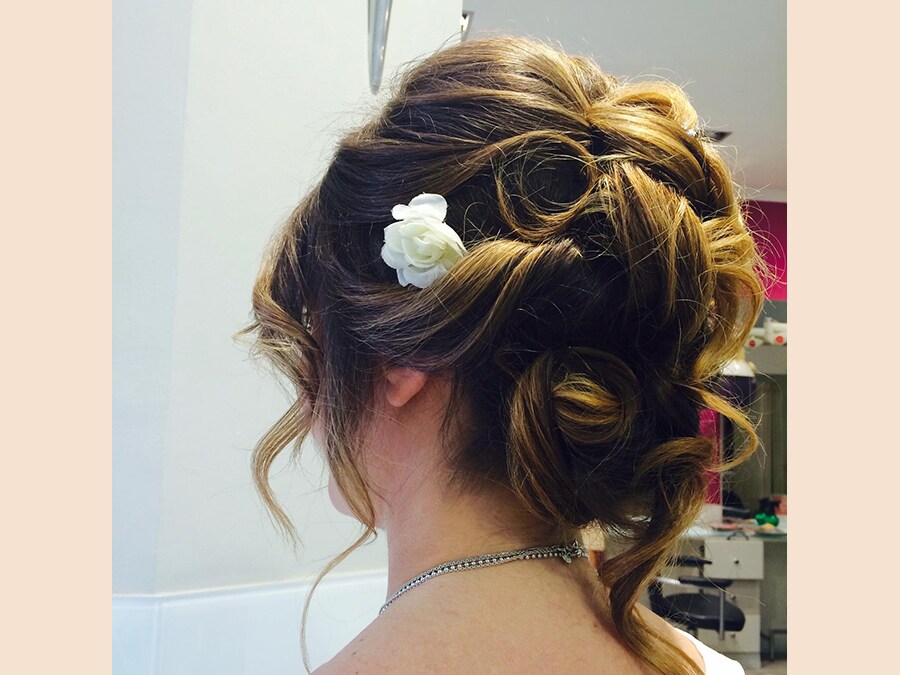 Mastromauro Hairstylist, mezza coda con torchon cotonati, impreziosita da fiori