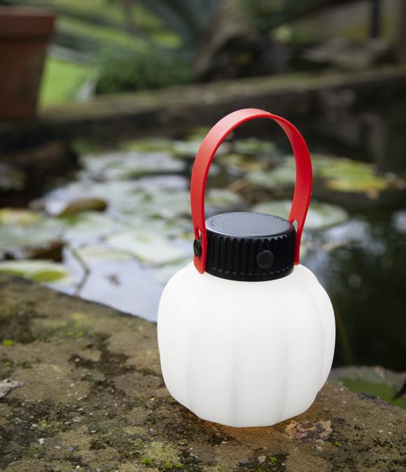 Martinelli Luce, Kiki cordless, design Paola Navone. Una piccola lanterna in puro stile giapponese, è Kiki in versione “pret-à-porter” della catenaria di luce per esterno di Paola Navone. Un'evoluzione a cui quel tocco di rosso del manico, che la caratterizza, per trasportarla ovunque regala un pizzico d'ironia. Kiki cordless ha una batteria ricaricabile (della durata di 5 ore) con cavo USB. Base stampata in resina di colore nero, cablata per sorgente di luce a LED integrato, con caricabatteria. Diffusore in polietilene stampato in rotazionale