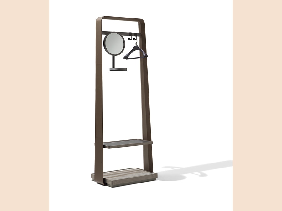 Giorgetti, Frame, design Carlo Colombo. Servomuto con base in acero disponibile in due finiture: grigio tortora (e grigio) e profilo laterale rivestito in cuoio. L'inserto della base è in marmo nelle varianti Calacatta oro, Portoro, Zebrino o Velvet Brown. Èprevista anche una versione con specchio e una con un ripiano aggiuntivo in acero. A completamento del prodotto sono disponibili come accessori ganci in metallo per appendere e uno specchio rotondo (nella foto), regolabile in altezza, con vassoio in acero e metallo verniciato color bronzo