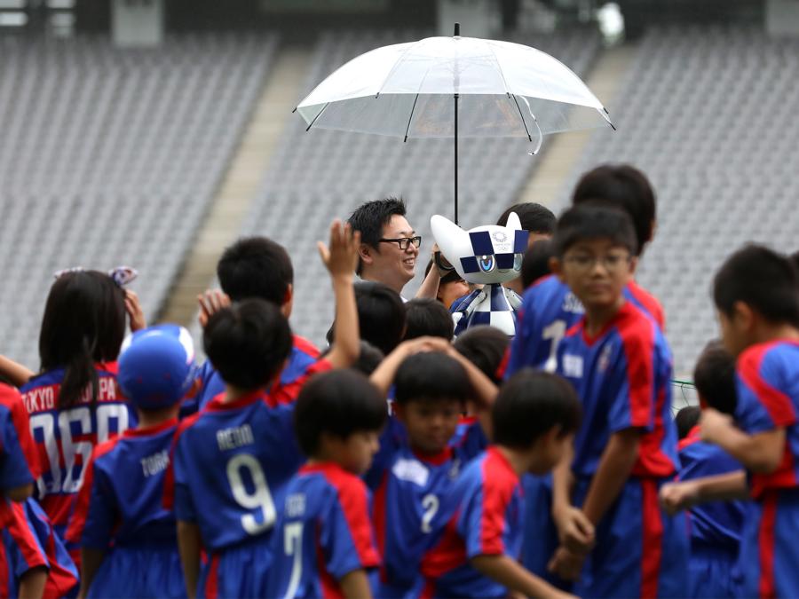 Bambini insieme alla mascotte Miraitowa (Photo by Behrouz MEHRI / AFP)