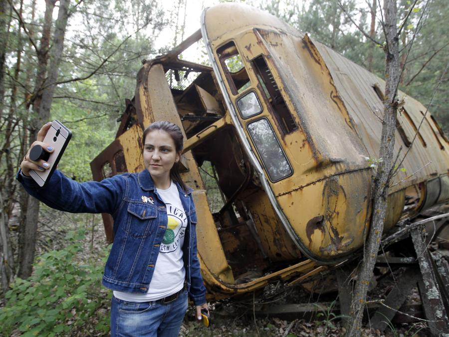 Selfie davanti a un bus  nella città fantasma di Pripyat (Photo by STR/NurPhoto)