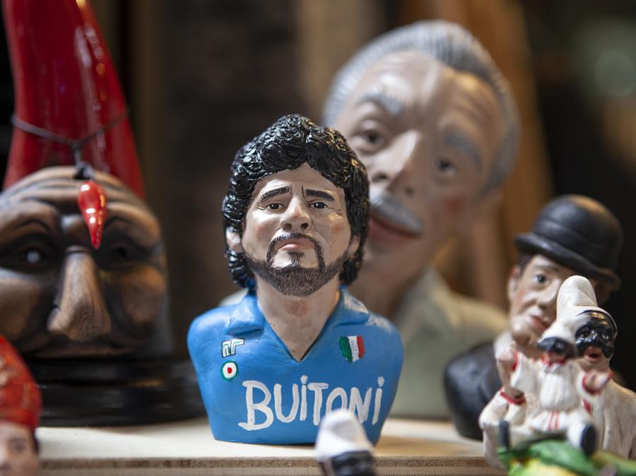 Una delle moltissime statuette ispirate a Maradona in vendita a San Gregorio Armeno, la «via dei presepi» e degli artigiani della terracotta. A differenza di altri soggetti, l’amato numero 10 è sempre ritratto in maniera solenne e reverenziale, un rispetto riservato a pochi simboli della napoletanità quali Eduardo De Filippo, Totò e San Gennaro. Napoli, agosto 2020. © Paolo Vezzoli