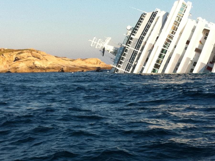 La nave da crociera Costa Concordia, incagliata ieri sera all'isola del Giglio, nell'arcipelago toscano, in una foto scattata all'alba 14 gennaio 2012. L'imbarcazione è inclinata di 80 gradi ed è vicino agli scogli. I 3000 passeggeri e i 1500 membri d'equipaggio sono stati evacuati sulle scialuppe e sistemati sull'isola in scuole, asili, alberghi e chiese. Tre le vittime accertate. MATTEO GUIDELLI / ANSA