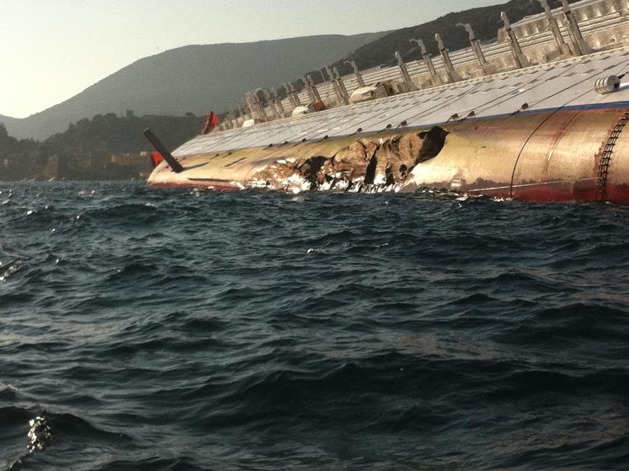 La nave da crociera Costa Concordia, incagliata ieri sera all'isola del Giglio, nell'arcipelago toscano, in una foto scattata all'alba 14 gennaio 2012. L'imbarcazione è inclinata di 80 gradi ed è vicino agli scogli. I 3000 passeggeri e i 1500 membri d'equipaggio sono stati evacuati sulle scialuppe e sistemati sull'isola in scuole, asili, alberghi e chiese. Tre le vittime accertate. MATTEO GUIDELLI / ANSA