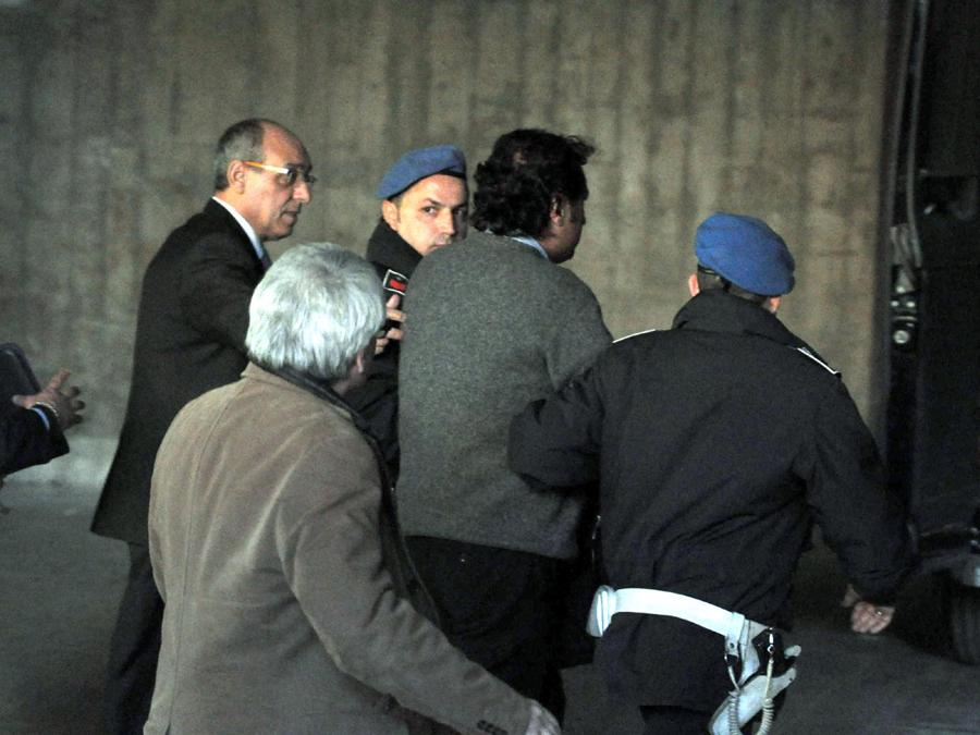 Il comandante della Costa Concordia Francesco Schettino (al centro tra due agenti di polizia penitenziaria) al termine dell'interrogatorio a Palazzo di Giustizia di Grosseto, 17 gennaio 2012, si dirige verso il cellulare della polizia per tornate in carcere dove attendera' la decisione del Gip. ANSA/ENZO RUSSO