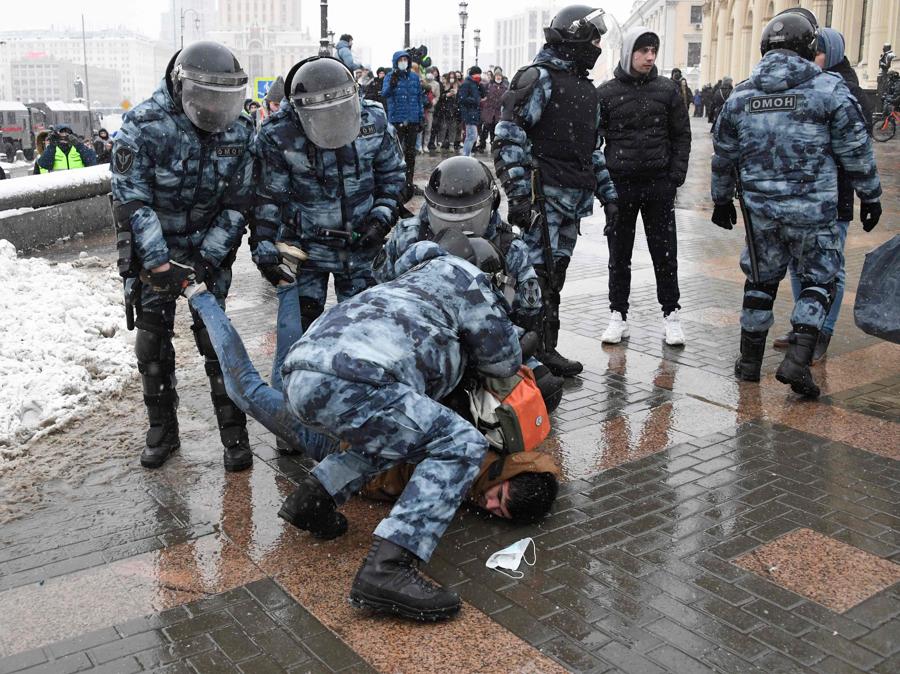 La polizia trattiene un uomo durante una manifestazione a sostegno del leader dell'opposizione in carcere Alexei Navalny a Mosca il 31 gennaio 2021. - Navalny, 44 anni, è stato arrestato il 17 gennaio dopo essere tornato a Mosca dopo cinque mesi in Germania, dopo aver subito un avvelenamento quasi fatale con un agente nervino e successivamente incarcerato per 30 giorni in attesa di processo per aver violato una condanna sospesa nel 2014. (Photo by Alexander NEMENOV / AFP)