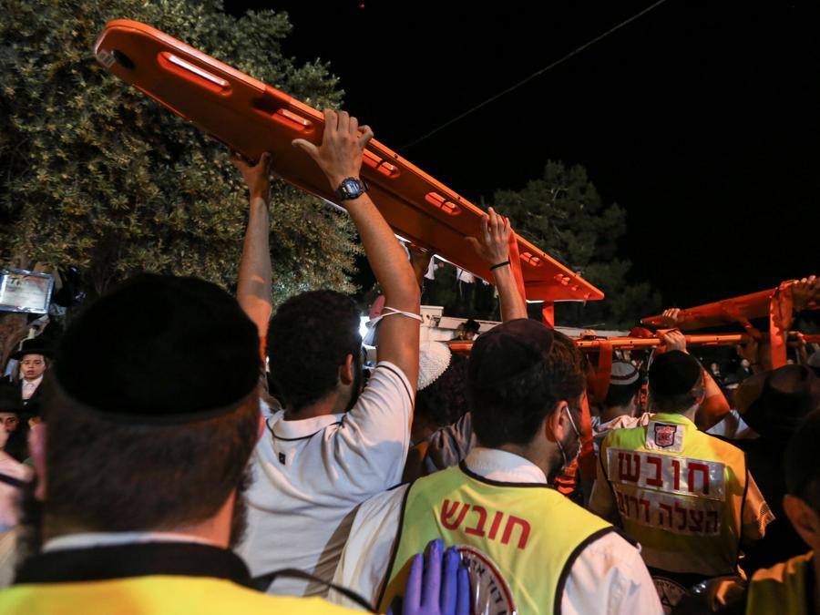 Medici e soccorritori partecipano all'evento Lag B'Omer a Mount Meron, nel nord di Israele, dove sono stati segnalati decessi tra le migliaia di ebrei ultraortodossi riuniti presso la tomba di un saggio del II secolo per commemorazioni annuali che includono la preghiera per tutta la notte e balla, al monte Meron. (REUTERS/ David Cohen-JINIPIX)