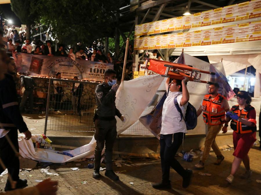 Un uomo trasporta una barella all'evento di Lag B'Omer a Mount Meron, nel nord di Israele, dove sono stati segnalati decessi tra le migliaia di ebrei ultraortodossi riuniti presso la tomba di un saggio del II secolo per commemorazioni annuali che includono la preghiera per tutta la notte e balla, al monte Meron. (REUTERS/ David Cohen-JINIPIX)