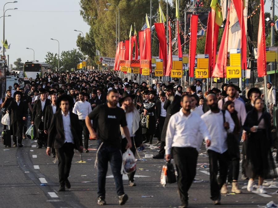 Credenti ebrei camminano sul Monte Meron, nel nord di Israele, dove sono state segnalate vittime tra le migliaia di ebrei ultraortodossi riuniti presso la tomba di un saggio del II secolo per commemorazioni annuali che includono la preghiera e la danza per tutta la notte (REUTERS/ Ronen Zvulun)
