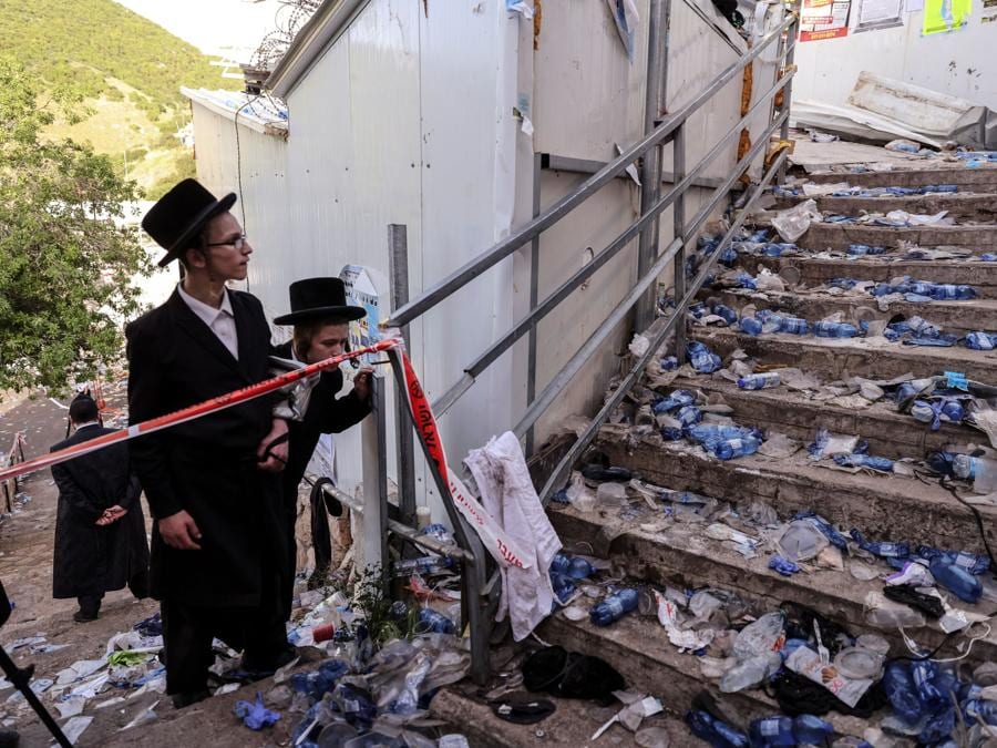 Ebrei ultra ortodossi guardano le scale con i rifiuti sul monte Meron, nel nord di Israele, dove sono stati segnalati incidenti mortali tra le migliaia di ebrei ultraortodossi riuniti presso la tomba di un saggio del II secolo per commemorazioni annuali che includono la preghiera e la danza per tutta la notte.( REUTERS/ Ronen Zvulun)