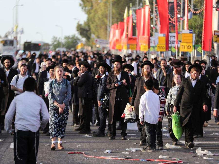 Credenti ebrei camminano sul Monte Meron, nel nord di Israele, dove sono state segnalate vittime tra le migliaia di ebrei ultraortodossi riuniti presso la tomba di un saggio del II secolo per commemorazioni annuali che includono la preghiera e la danza per tutta la notte (REUTERS/ Ronen Zvulun)