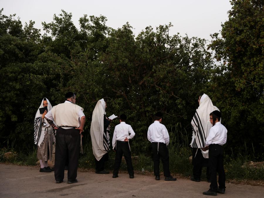 Gli ebrei pregano la loro preghiera mattutina sul Monte Meron, nel nord di Israele, dove sono stati segnalati incidenti mortali tra le migliaia di ebrei ultraortodossi riuniti presso la tomba di un saggio del II secolo per commemorazioni annuali che includono la preghiera e la danza per tutta la notte (REUTERS/ Ronen Zvulun)