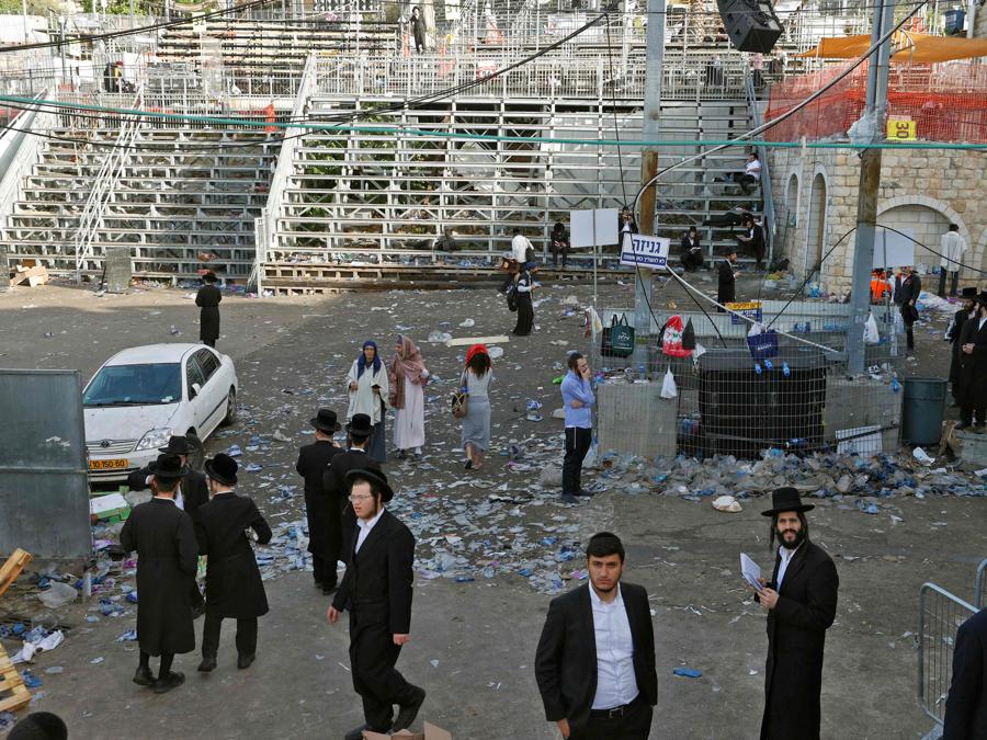 Uomini ebrei ortodossi si riuniscono all'inizio del 30 aprile 2021 nella città israeliana settentrionale di Meron sulla scena di una fuga precipitosa avvenuta durante la notte durante un raduno religioso vicino alla famosa tomba del rabbino Shimon Bar Yochai, un saggio talmudico del II secolo, dove principalmente ebrei ultraortodossi si accalcano per celebrare la festa di Lag BaOmer. - Una massiccia fuga precipitosa nel sito di pellegrinaggio ebraico densamente popolato ha ucciso almeno 44 persone nel nord di Israele la mattina presto, con i soccorritori che hanno affrontato folle caotiche mentre cercavano di evacuare i feriti. (Photo by JACK GUEZ / AFP)