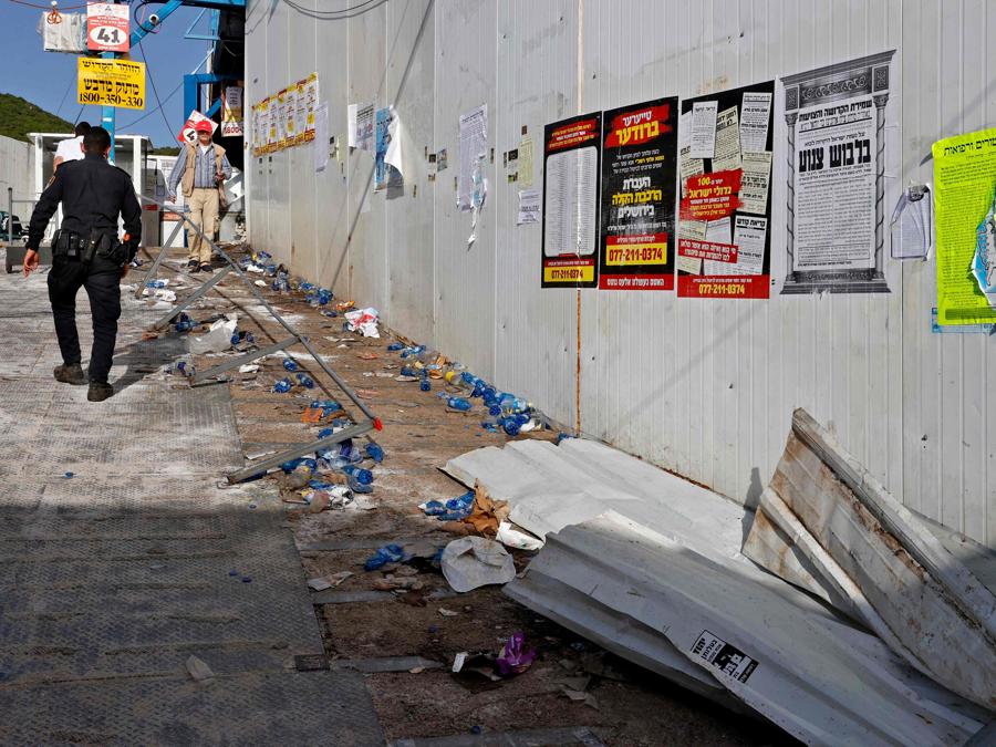 Un membro delle forze di sicurezza cammina il 30 aprile 2021 attraverso la scena di una fuga precipitosa avvenuta durante un raduno religioso durante la notte nella città israeliana settentrionale di Meron naer, la famosa tomba del rabbino Shimon Bar Yochai, un saggio talmudico del II secolo, dove principalmente ebrei ultraortodossi si accalcano per celebrare la festa di Lag BaOmer. - Una massiccia fuga precipitosa nel sito di pellegrinaggio ebraico densamente popolato ha ucciso almeno 44 persone nel nord di Israele la mattina presto, con i soccorritori che hanno affrontato folle caotiche mentre cercavano di evacuare i feriti. (Photo by JACK GUEZ / AFP)