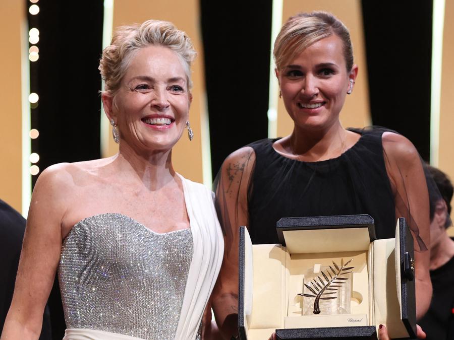 La regista francese Julia Ducournau (a destra) posa sul palco con l’attrice statunitense Sharon Stone dopo aver vinto la Palma d’oro per il suo film “Titane” durante la cerimonia di chiusura della 74a edizione del Festival di Cannes . (Photo by Valery HACHE / AFP)