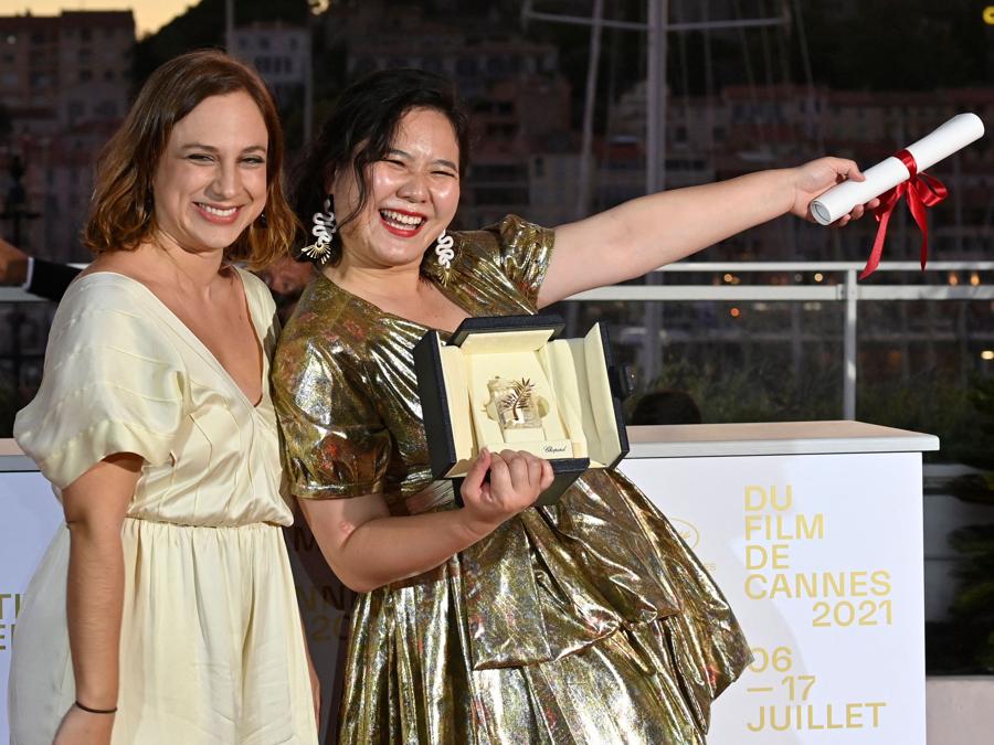 La regista di Hong Kong Tang Yi (R) posa con la regista brasiliana Jasmin Tenucci dopo aver vinto la Palma d’oro Cortometraggio per il suo film “All the Crows in the World” durante la cerimonia di chiusura della 74a edizione del Festival di Cannes . (Photo by John MACDOUGALL / AFP)