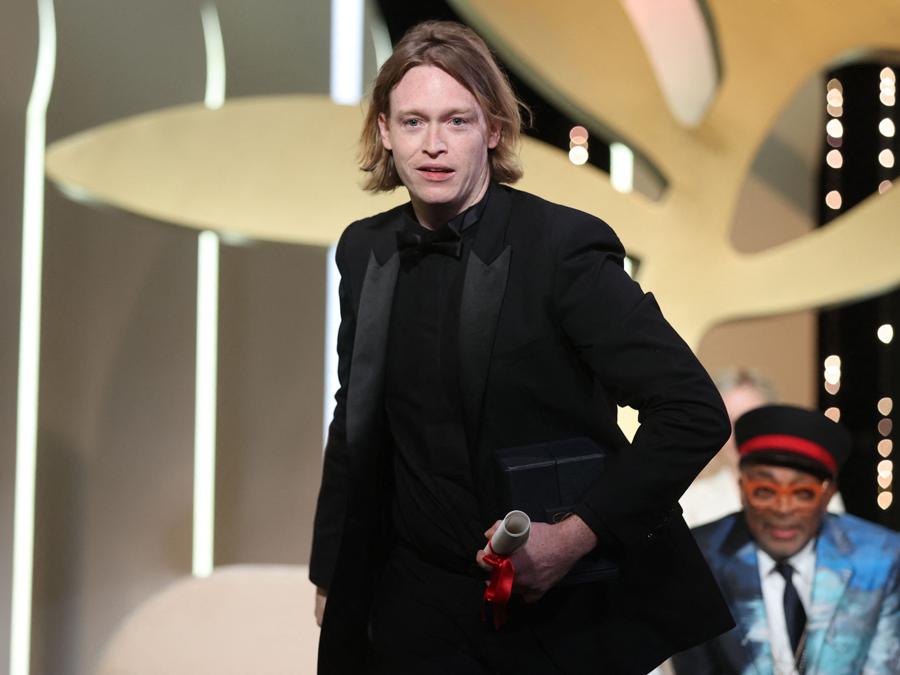 L’attore statunitense Caleb Landry Jones sul palco dopo aver ricevuto il premio come miglior attore, alla 74a edizione del Festival di Cannes, per la sua parte nel film “Nitram” . (Photo by Valery HACHE / AFP)