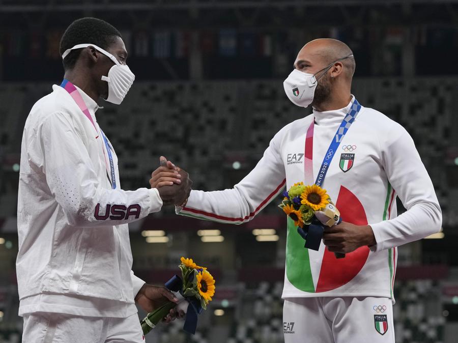 La medaglia d’oro Lamont Marcell Jacobs (Italia), si congratula, sul podio, con l’americano medaglia d’argento Fred Kerley (a sinistra)  (AP Photo/Francisco Seco)