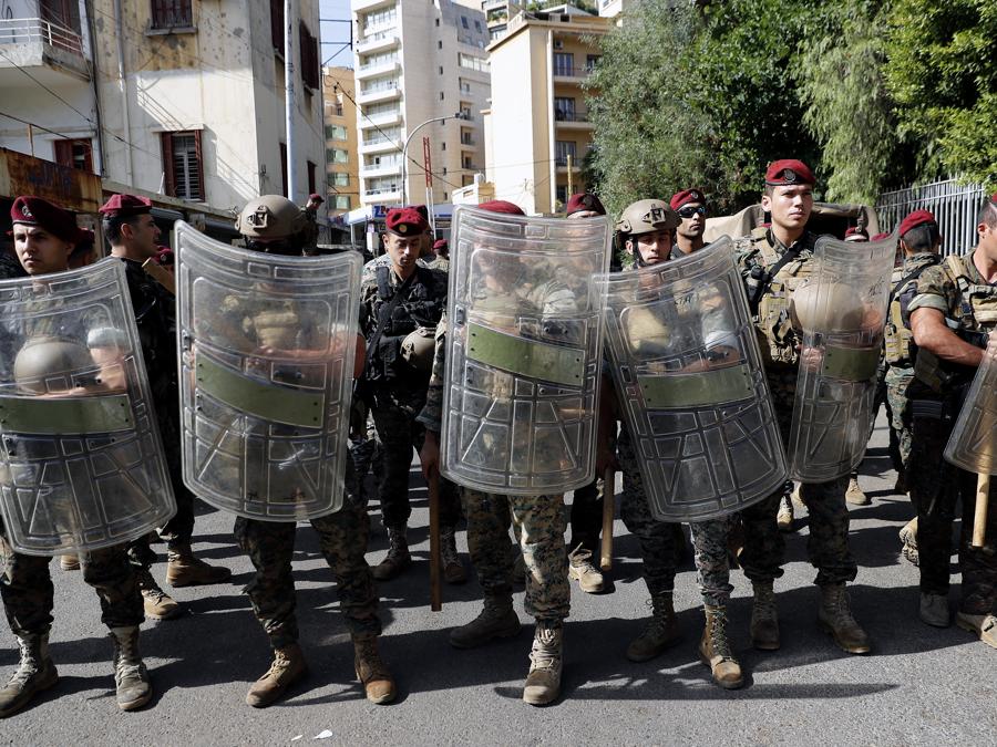 L’esercito libanese fa la guardia vicino al Palazzo di Giustizia mentre i sostenitori dei gruppi sciiti Hezbollah e Amal protestano contro il giudice Tarek Bitar che sta indagando sull’esplosione mortale del porto marittimo dello scorso anno, a Beirut, in Libano (AP Photo/Hussein Malla)