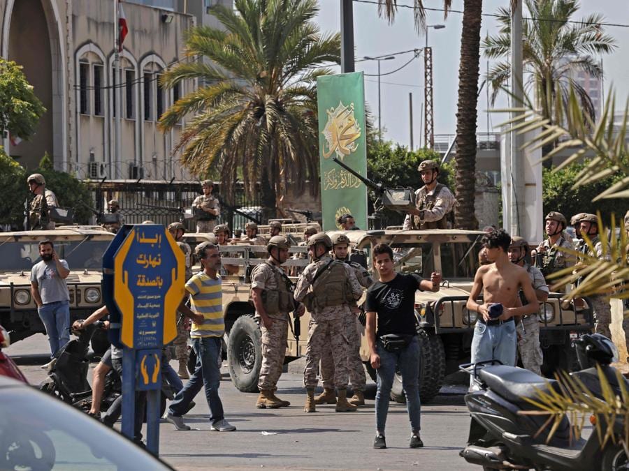 I soldati dell’esercito libanese prendono posizione nella zona di Tayouneh, nel sobborgo meridionale della capitale Beirut, il 14 ottobre 2021, dopo gli scontri seguiti a una manifestazione dei sostenitori di Hezbollah e del movimento Amal. - Gli spari hanno ucciso almeno una persona e ne hanno ferite otto durante una manifestazione a Beirut organizzata dai movimenti sciiti Hezbollah e Amal per chiedere il licenziamento dell’investigatore capo dell’esplosione di Beirut, ha detto la dottoressa Mariam Hassan dell’ospedale Sahel nella periferia sud di Beirut. (Photo by JOSEPH EID / AFP)