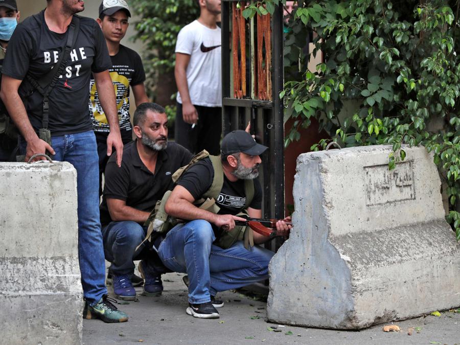Combattenti del movimento Amal si radunano durante gli scontri nell’area di Tayouneh il 14 ottobre 2021. - Gli spari hanno ucciso almeno tre persone e ne hanno ferite 20 durante una manifestazione a Beirut organizzata dai movimenti sciiti Hezbollah e Amal per chiedere il licenziamento del responsabile dell’esplosione di Beirut. (Photo by ANWAR AMRO / AFP)