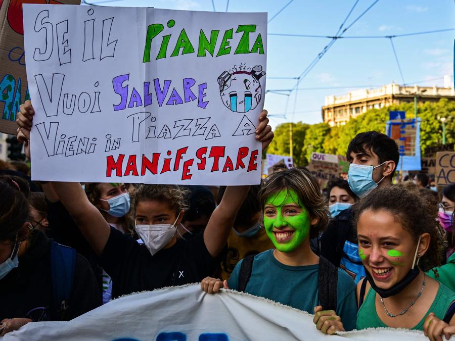 Giovani attivisti per il clima marciano durante uno sciopero degli studenti Fridays for Future il 1 ottobre 2021 a margine degli eventi Youth4Climate e Pre-COP 26 a Milano. - Il cartello dice “se vuoi salvare il pianeta, vieni in piazza e manifesta”. (Photo by MIGUEL MEDINA / AFP)