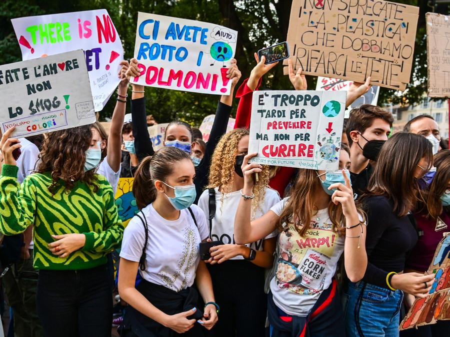 Giovani attivisti per il clima marciano durante uno sciopero degli studenti Fridays for Future il 1 ottobre 2021 a margine degli eventi Youth4Climate e Pre-COP 26 a Milano. - Il cartello dice “se vuoi salvare il pianeta, vieni in piazza e manifesta”. (Photo by MIGUEL MEDINA / AFP)