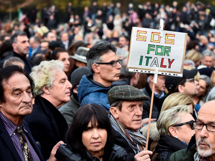 Una persona porta  uno striscione a una manifestazione contro le vaccinazioni contro il coronavirus (COVID-19), a Milano (REUTERS/Flavio Lo Scalzo)