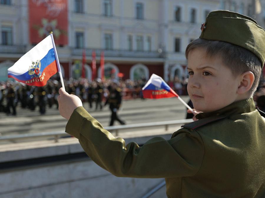 Un ragazzo  indossa l’uniforme in stile Armata Rossa guarda una parata il giorno della vittoria, che segna il 77° anniversario della vittoria sulla Germania nazista nella seconda guerra mondiale, a Vladivostok. REUTERS/Tatiana Meel